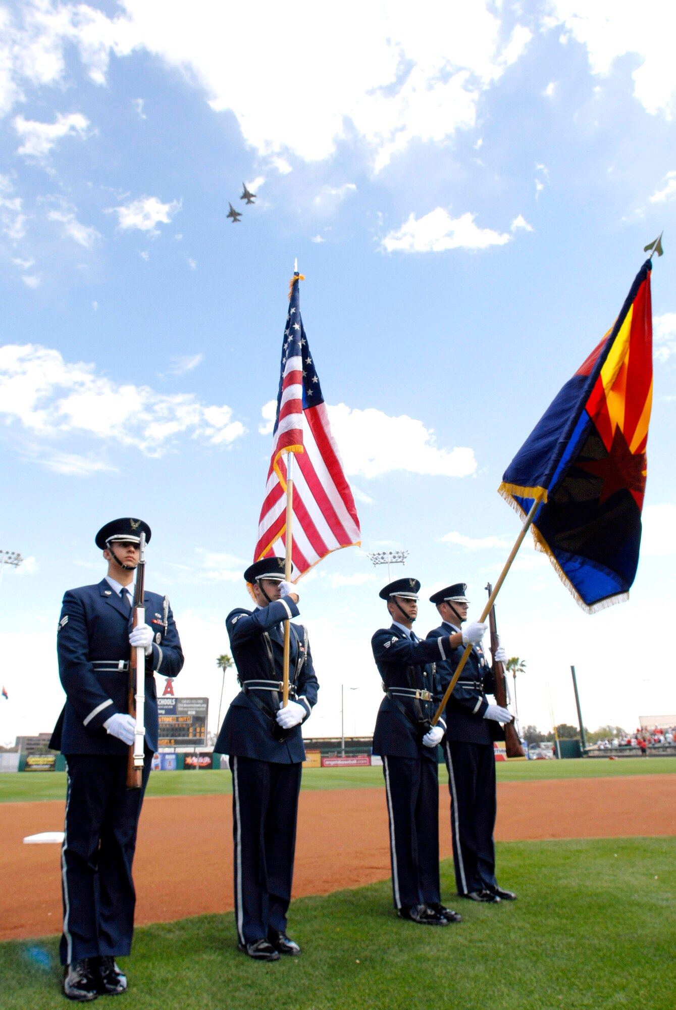 The Luke Air Force Base Honor Guard display the colors while the 61st Fighter Squadron performs a flyover for the Arizona Diamondbacks and Anaheim Angels game March 21. Servicemembers were invited to the game in support of Air Force Week. (U.S. Air Force photo/Senior Airman Christopher Hummel)
