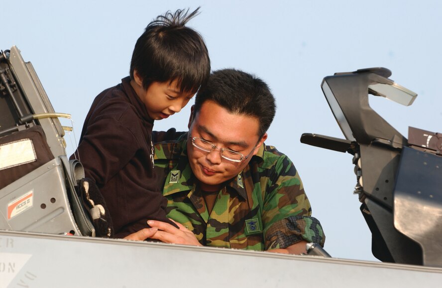 OSAN AIR BASE, Republic of Korea --  A Korean NCO shows a child the cockpit of a Korean KF-16 Fighting Falcon during the 2006 Air Power Day air show here. The Korean version of the F-16 is very similar to the U.S. version. (U.S. Air Force photo by Airman Jason Epley)
