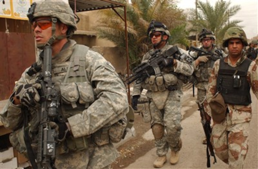 U.S. Army Staff Sgt. Juan Alba (left),  Cpl. Joseph Casiano (2nd from left), Spc. David Tunstall (3rd from left) and an Iraqi National Police officer conduct a combined cordon and search foot patrol at a market in Ghazaliya, Iraq, on March 23, 2007.  The soldiers are from Black Hawk Company, 1st Battalion, 23rd Infantry Regiment, 3rd Brigade Combat Team, 2nd Infantry Division.  