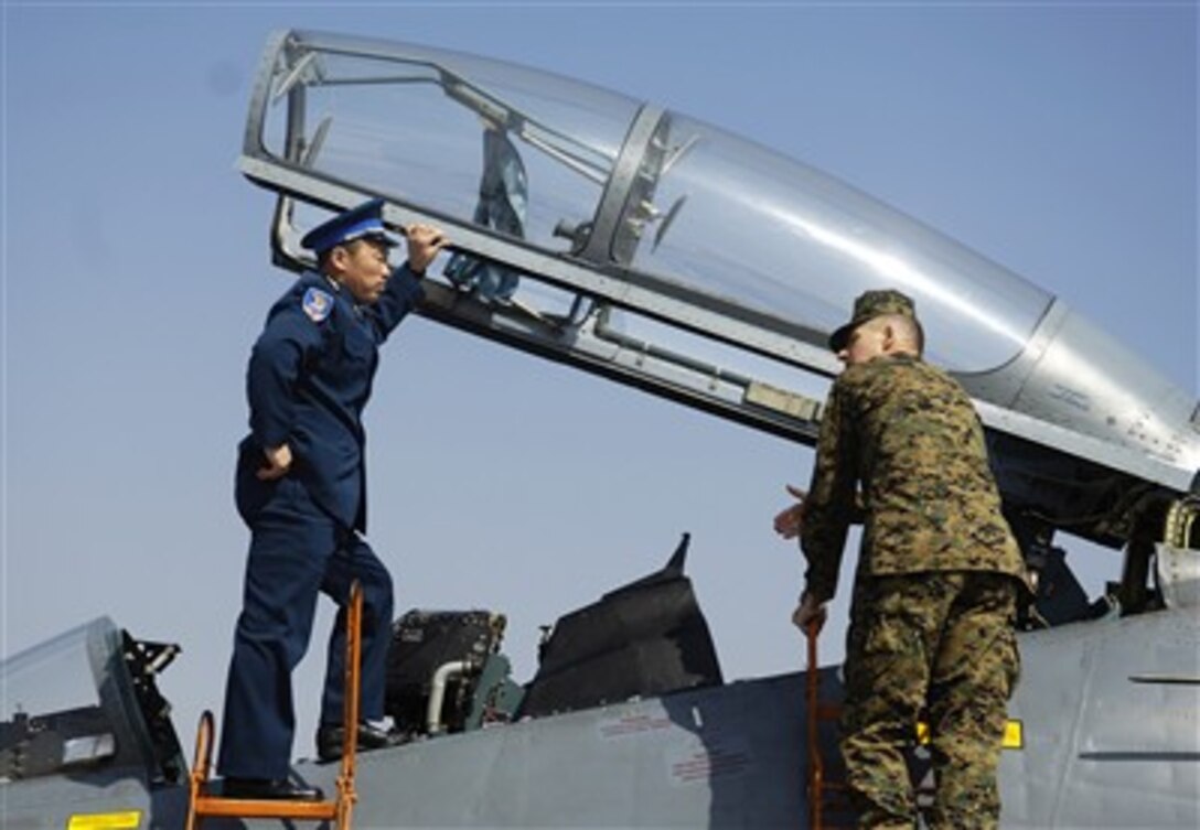 Chinese Air Force senior Col. Wang Wei and Chairman of the Joint Chiefs of Staff Gen. Peter Pace, U.S. Marine Corps, talk air power while looking into the cockpit of a Chinese Su-27 Flanker fighter aircraft at Anshan Airfield, China, on March 24, 2007. 