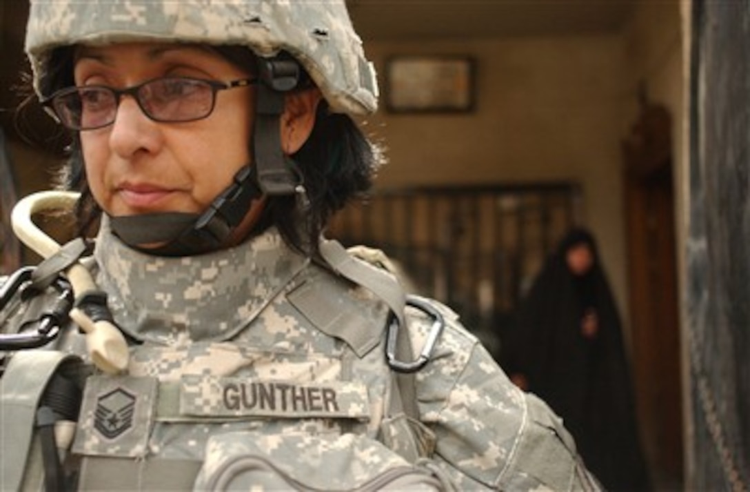 U.S. Air Force Master Sgt. Coco Gunther, from the 1st Combat Camera Squadron, observes her surroundings during a combined cordon and search mission with Army soldiers from 3rd Brigade Combat Team, 2nd Infantry Division and Iraqi army soldiers in Ghazaliya, Iraq, March 21, 2007. 