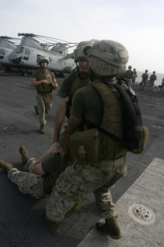 Marines of Company E, Battalion Landing Team 2/2, drag a simulated casualty to an evacuation point aboard USS Bataan, March 28, while practicing their patrolling and evacuation skills.