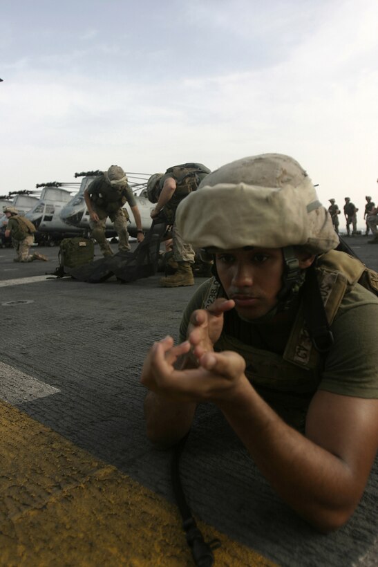 Lance Corporal Clinton Velten, Company E, Battalion Landing Team 2/2, maintains security as the other Marines of E Co. prepare to move a simulated casualty aboard USS Bataan, March 28.  The Marines and Sailors of E Co. were practicing patrolling and evacuation drills to increase the chances of a casualty's survival if one were to occur in combat.  Photo by Staff Sgt. Trent Kinsey