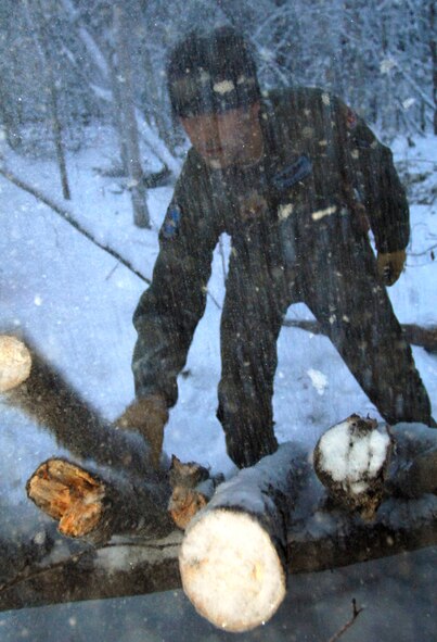 An F-15C pilot, Capt. Matt Misner of the 390th Fighter Squadron, Mountain Home Air Force Base, Idaho, collects wood for a one-man shelter while spending a day isolated from other students. Fighter pilots go through a more intense version of the course than everyone else because they usually fly alone and need to be able to depend on their skills rather than a group. (Photo by Staff Sgt. Matthew Hannen)