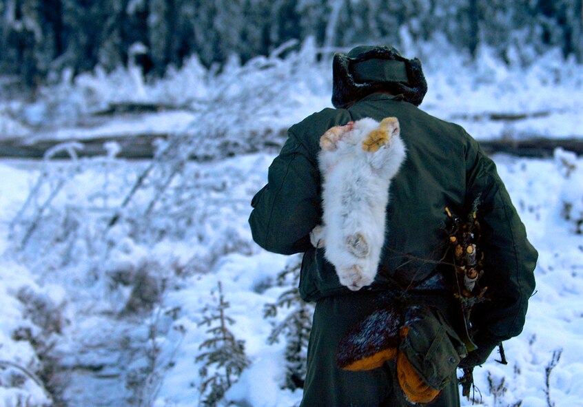 School's in session and Staff Sgt. Daniel Melott, of the 962nd Airborne Air Control Squadron, Elmendorf Air Force Base, Alaska, carries, his lunch, a rabbit, and some fire wood back to camp. (Photo by Staff Sgt. Matthew Hannen)