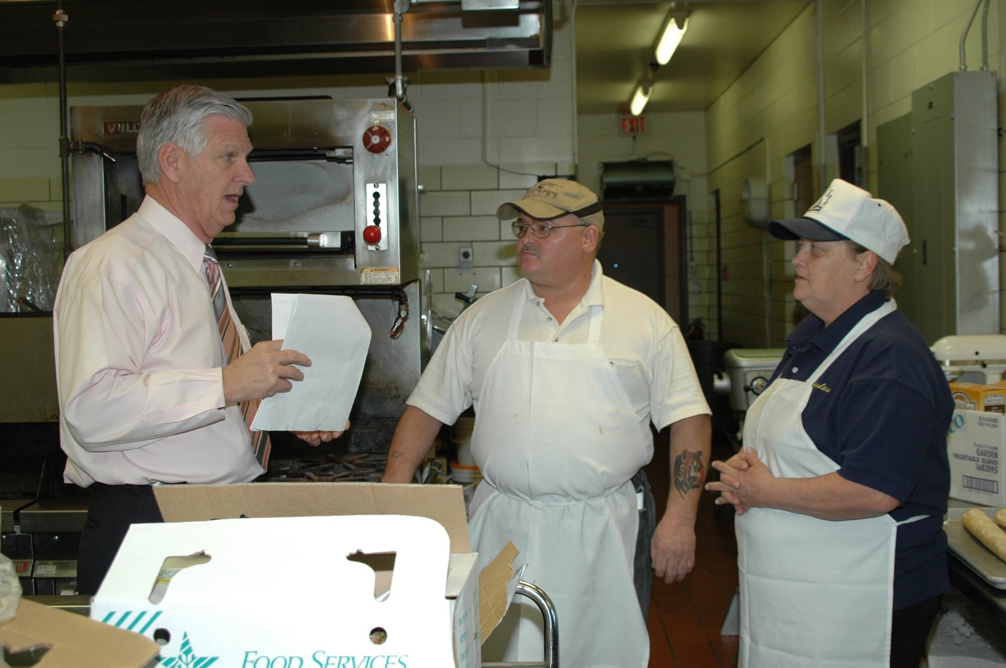 Garry Shaffer, Dakota's manager, speaks with Ms. Nancy Powers and Mr. Edward Newigham, Dakota's cooks, as they prepare to serve lunch.
Mr. Shaffer is the club's new manager and looks forward to revamping the club.