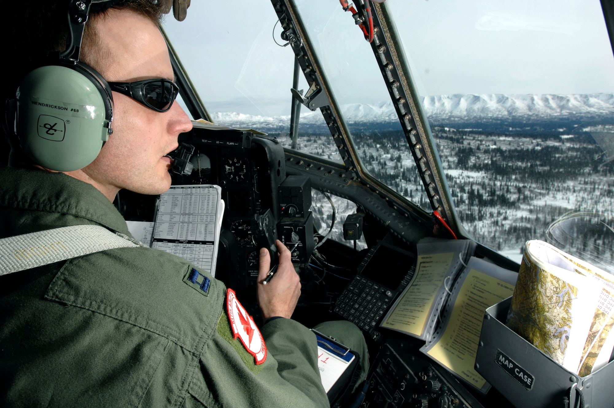 Capt. Ryan Hendrickson looks out over the vast Alaska wilderness during the final flight March 23 of a C-130 Hercules belonging to the 517th Airlift Squadron.  After 43 years of continuous service in Alaska, the flight marked the end of the C-130 era at the 517th.  Airmen at Elmendorf soon will see C-17 Globemaster IIIs taking over the airlift mission. (U.S. Air Force photo/ Tech Sgt Keith Brown)