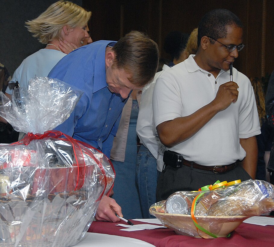 Col. Lansen Conley, vice commander of the 82nd Training Wing, and Lt. Col. Linnes Chester Jr., deputy commander of the 882nd Training Group, ponder which baskets to bid on during the inaugural Air Force Assistance Fund Basket Auction March 20 at the Sheppard Club. The auction raised more than $5,700 for the AFAF Campaign. (U.S. Air Force photo/Mike Litteken)