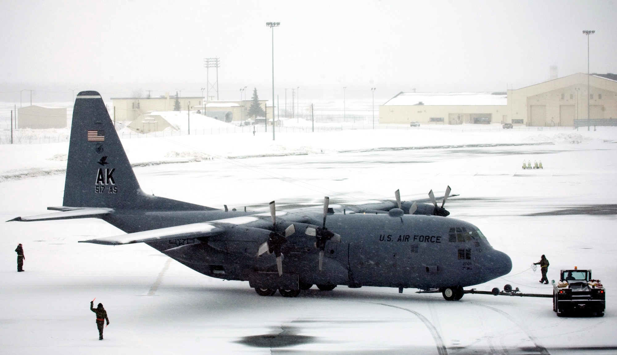 A snow-covered C-130 Hercules assigned to the 517th Airlift Squadron at Elmendorf Air Force Base, Alaska, is towed into place for post operational procedures March 23 following a shut-down ceremony.  After 43 years of continuous service in Alaska, the ceremony marked the end of the C-130 era at the 517th.  Airmen at Elmendorf soon will see C-17 Globemaster IIIs taking over the airlift mission. (U.S. Air Force photo/Senior Airman Garrett Hothan) 