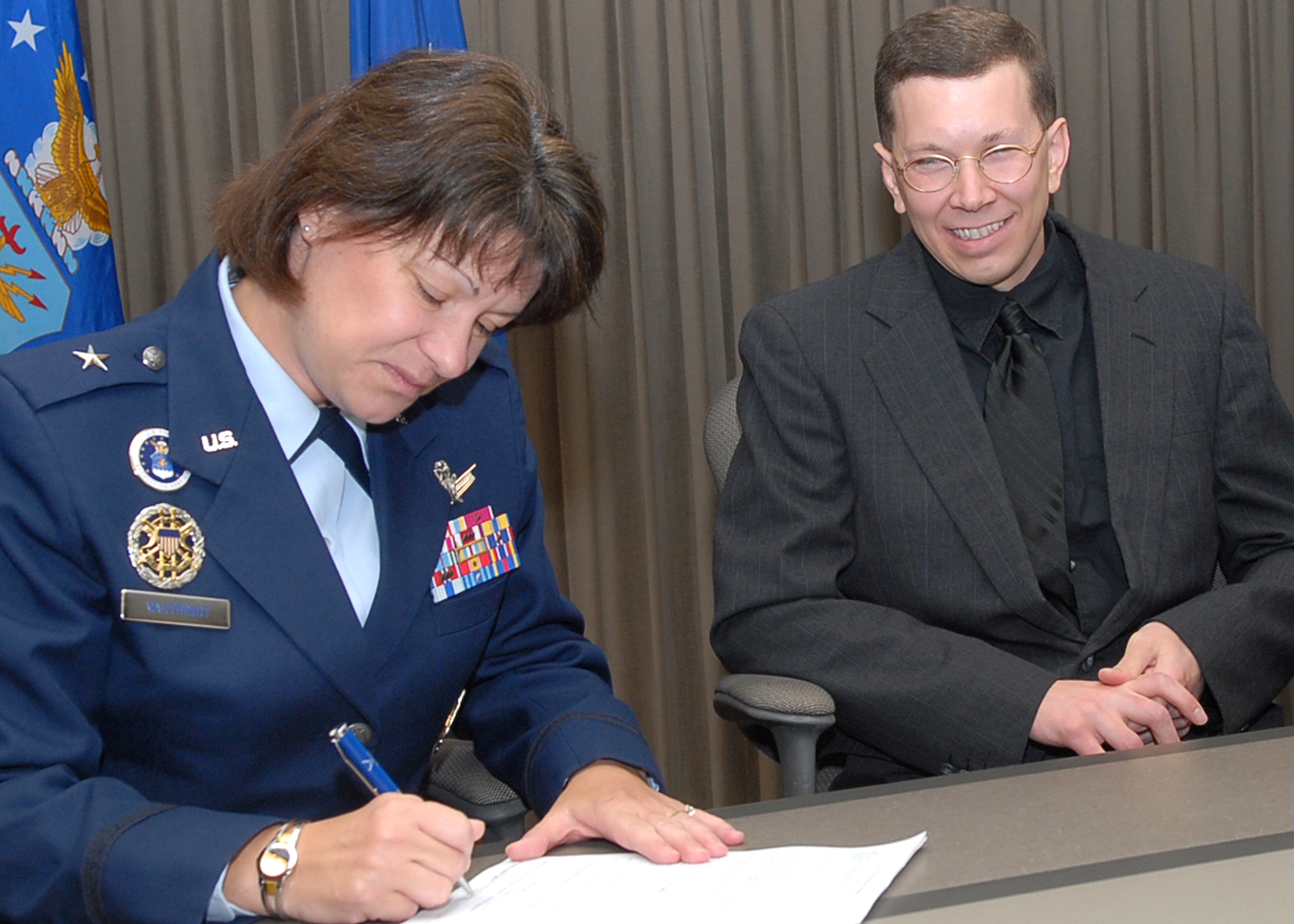 Brig. Gen. Suzanne Vautrinot, Air Force Recruiting Service commander, signs forms for newly commissioned 2nd Lt. Brian Wood. Under the Air Force Chaplain Candidate program, the former active-duty Airman will attend seminary full time as an Inactive Ready Reservist. Upon graduation, with his diocese' endorsement, he will be eligible for reappointment as an active-duty Catholic chaplain. (U.S. Air Force photo/Rich McFadden)