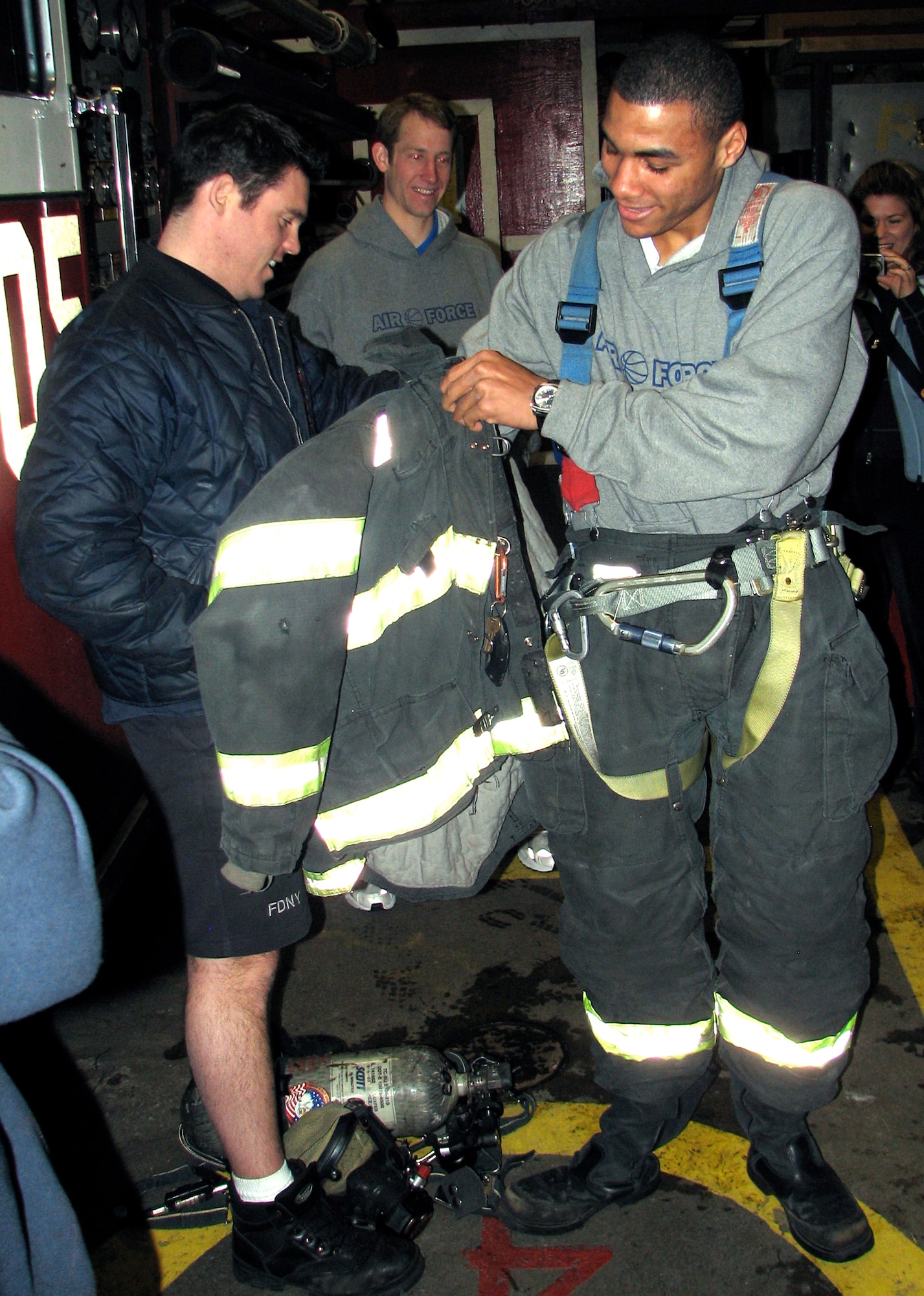 Cadet 1st Class Matt McCraw puts on a fireman's coat March 25 during a tour of the Engine 54 fire station in New York City. The senior is a member of the U.S. Air Force Academy men's basketball team, and is playing in the National Invitation Tournament semifinals March 27 against the Clemson Tigers in Madison Square Garden. (U.S. Air Force photo/Staff Sgt. Steve Grever) 