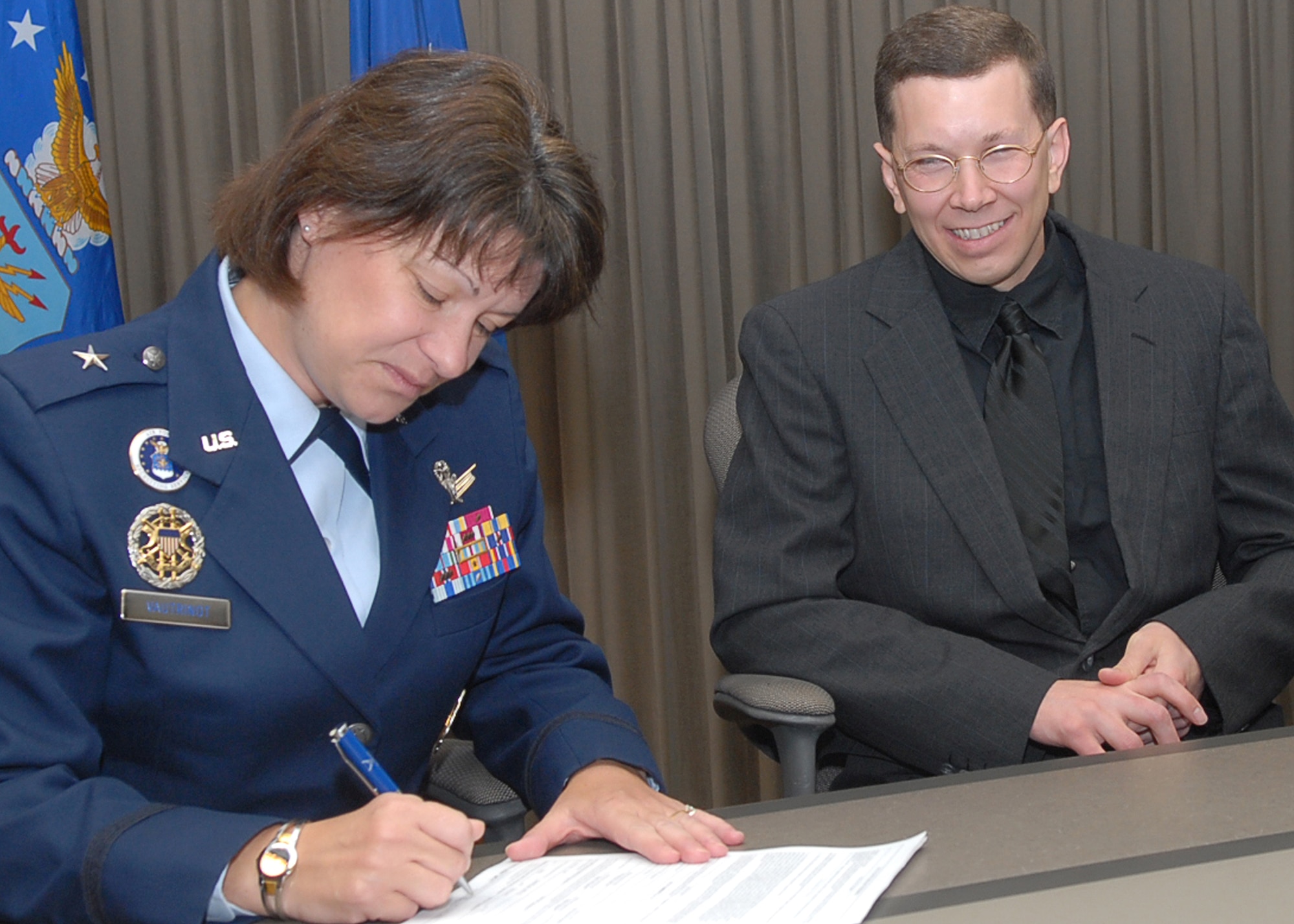 Brig. Gen. Suzanne Vautrinot, Air Force Recruiting Service commander, signs forms for newly commissioned 2nd Lt. Brian Wood Feb. 28. Under the Air Force Chaplain Candidate program, the former active-duty Airman will attend seminary full time as an Inactive Ready Reservist. Upon graduation, with his diocese' endorsement, he will be eligible for reappointment as an active-duty Catholic chaplain. (U.S. Air Force photo by Rich McFadden)