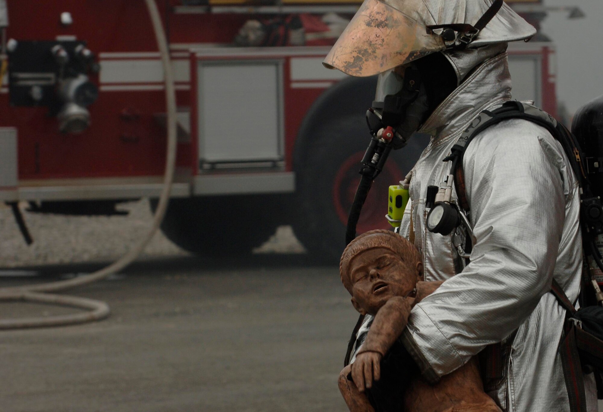 Airman 1st Class Robert Merkle III, Langley firefighter,  simulates a child rescue during the training session here March 21. These training scenarios prepare the fire fighters mentally and physically for the challenges of the job.  (U.S. Air Force photo/Airman First Class Christopher L. Ingersoll)