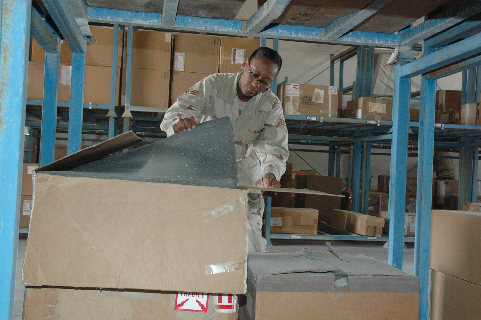 Senior Airman Taneshia Steward, 379th Expeditionary Logistics Readiness Squadron storage journeyman, repacks B-1B parts at the newest 379th ELRS storage facility. The use of pre-positioned aircraft parts stored in warehouses is part of the transition from expeditionary to an enduring presence. (Photo by Senior Airman Erik Hofmeyer)