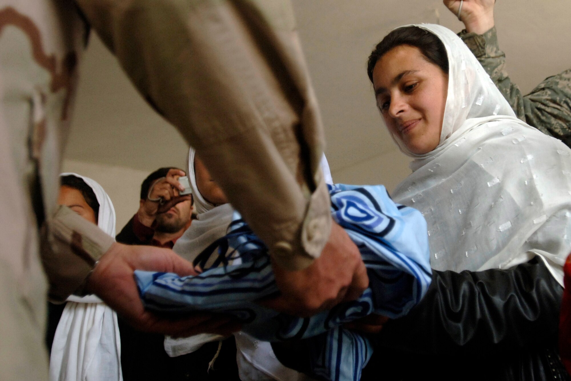 A local Afghan student receives donated school supplies from Brig. Gen. Christopher Miller at the Mahmud Raqi High School in the town of Deh Baba Ali, Afghanistan, March 26. Bagram Provincial Reconstruction Team members aided in building the high school and donated approximately 3,000 pine and fruit trees along with several bundles of school supplies. General  Miller is the 455th Expeditionary Wing commander. (U.S. Air Force photo/Tech. Sgt. Cecilio M. Ricardo Jr.)