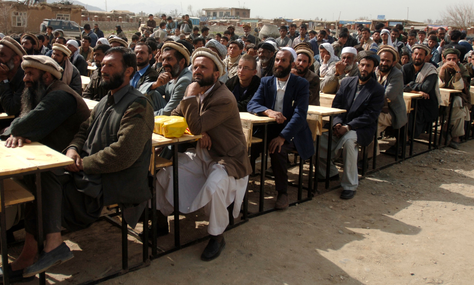 Hundreds of local Afghan men and women, along with Bagram Provincial Reconstruction Team members, attend a ceremony celebrating the Afghan New Year and the first day of school at the Mahmud Raqi High School in Deh Baba Ali, Afghanistan, March 26.  Bagram PRT Team members aided in building the high school and donated approximately 3,000 pine and fruit trees along with several bundles of school supplies. (U.S. Air Force photo/Tech. Sgt. Cecilio M. Ricardo Jr.)