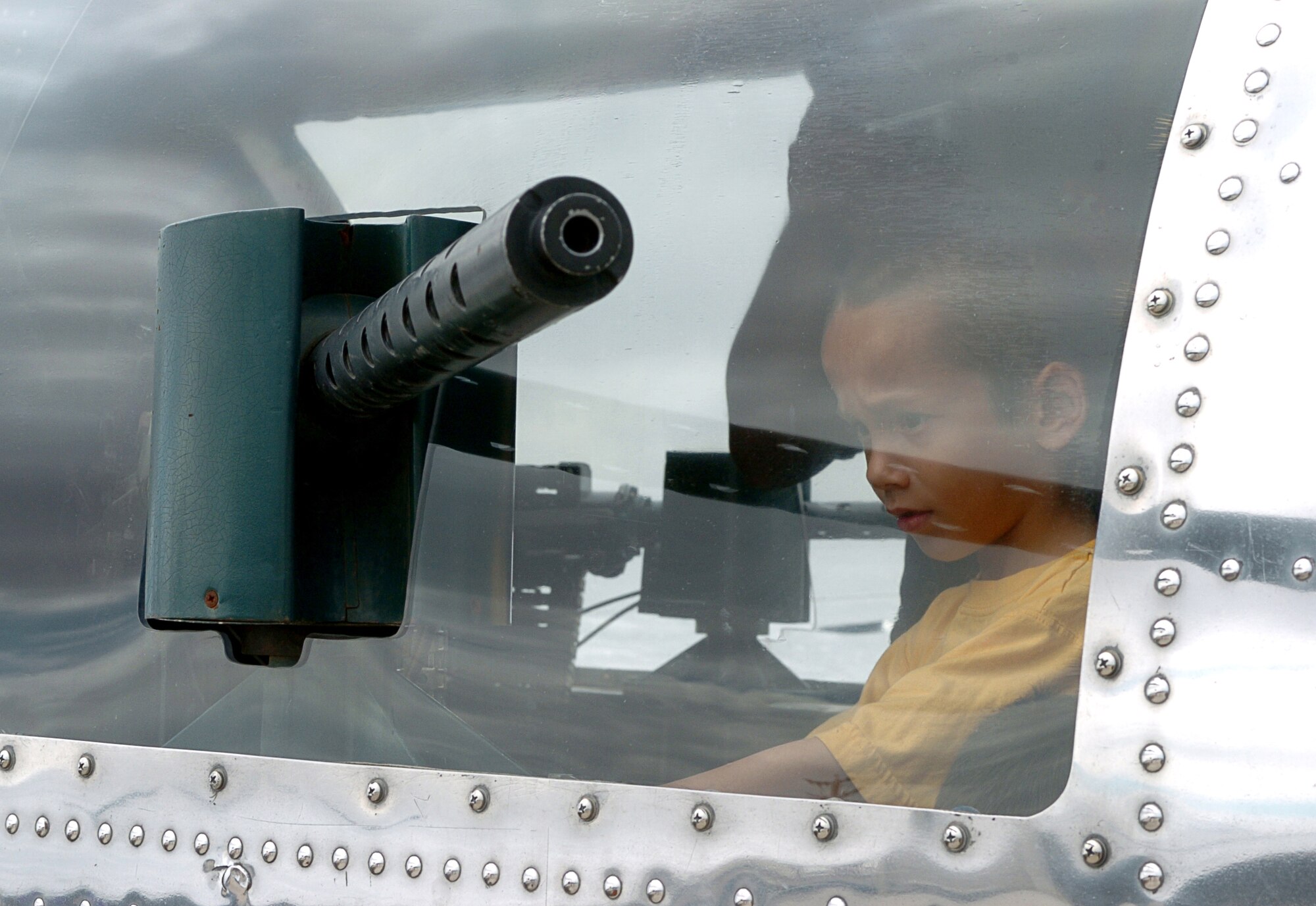 A young boy checks out the gun in a 1944 B-17 during "The Show of Force 2007, From Heritage to Horizons Air Show" at Luke Air Force Base, Ariz., March 24.  The show was part of Air Force Week, a week-long event designed to highlight the amazing things the Air Force is doing around the globe and to show appreciation to the local community for its support.  (U.S. Air Force photo/Staff Sgt. Brian Ferguson)