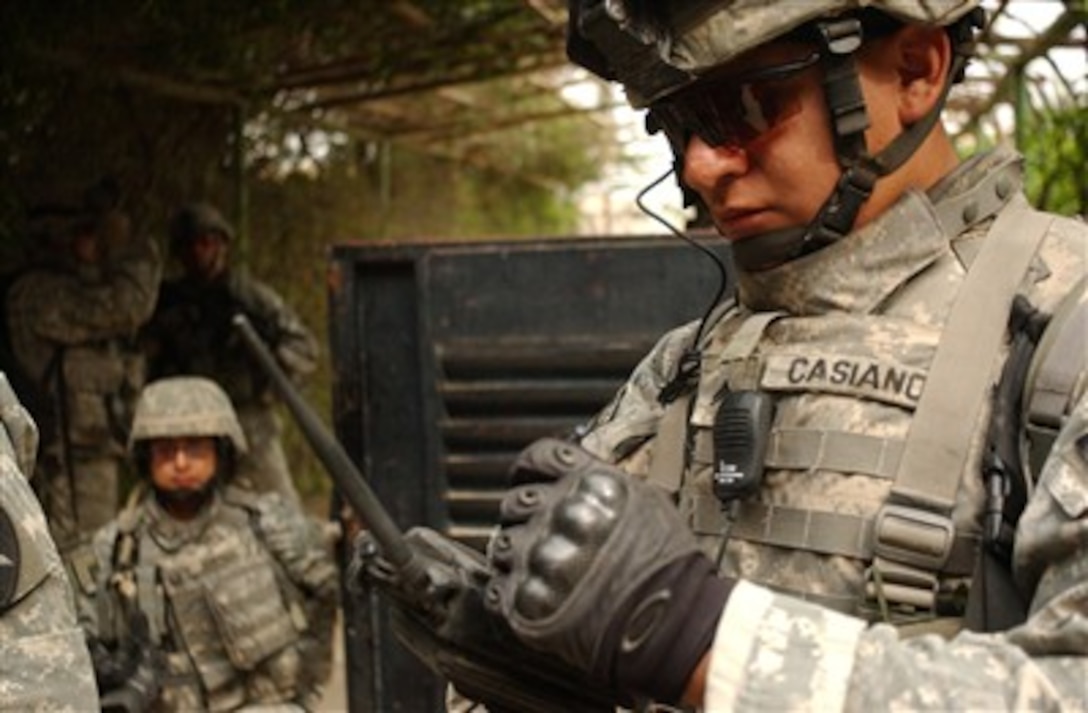 U.S. Army Cpl. Joseph Casiano plugs information into a personal data assistant during a combined cordon and search mission with the Iraqi National Police in Ghazaliya, Iraq, on March 23, 2007.  Casiano is attached to Black Hawk Company, 1st Battalion, 23rd Infantry Regiment, 3rd Stryker Brigade Combat Team, 2nd Infantry Division.  