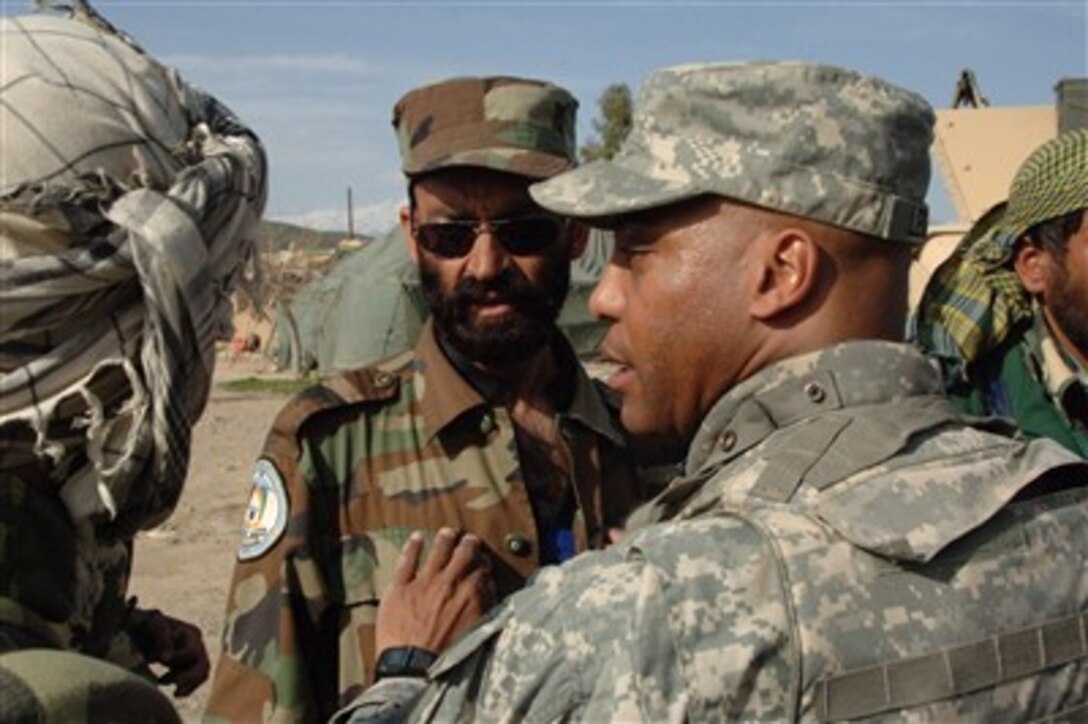 U.S. Army Sgt. 1st Class Rudolph Leonard talks with an Afghan National Police officer who is in need of medical attention at Border Checkpoint 9 in the Jaji Maidan District of Khowst Province, Afghanistan, on March 25, 2007.  Leonard is attached to the 203rd Regional Police Advisory Team.  