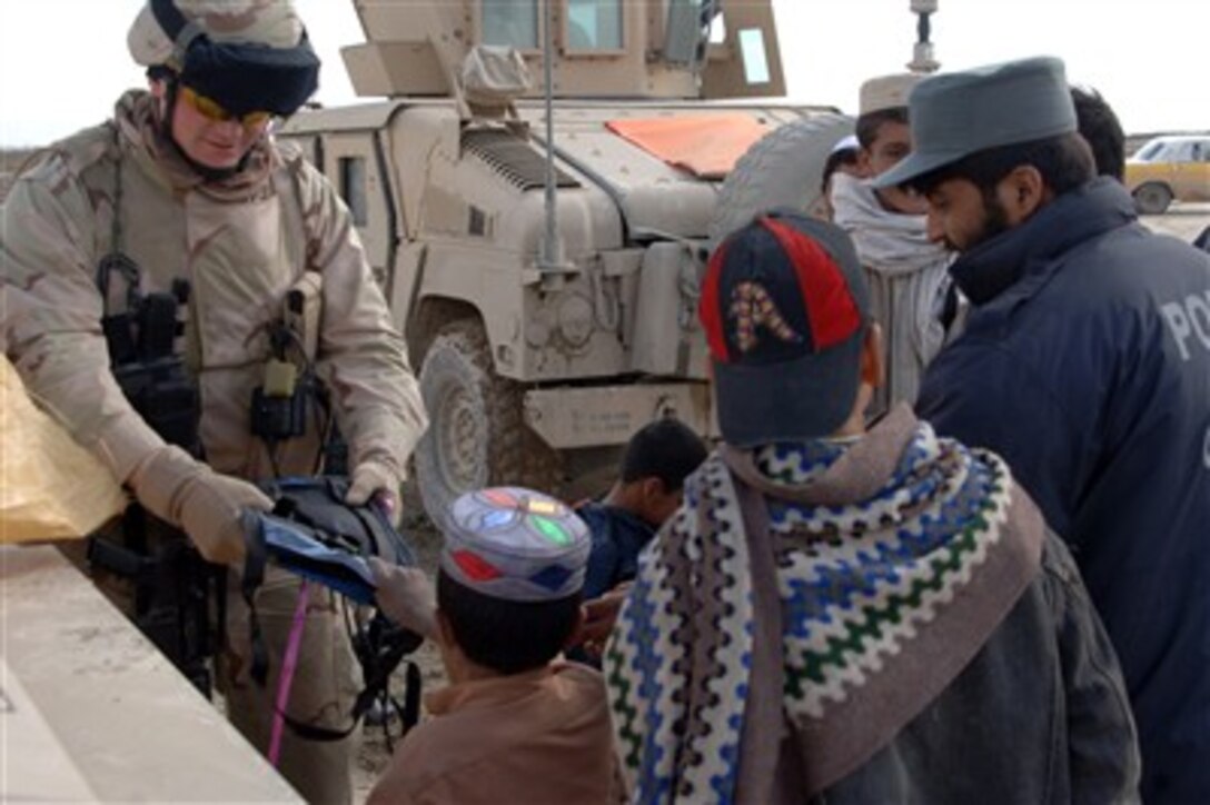 U.S. Air Force 1st Lt. Noah Diehl, of the Gardez Provincial Reconstruction Team, gives school supplies to children during a joint patrol of coalition forces and Afghanistan National Police in the Zormat province of Afghanistan March 21, 2007. 