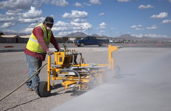 Jose Munez, a construction crew member, utilizes a machine to drill holes into the side of the concrete during work on the ongoing flight line construction project, head by the 99th Civil Engineering Squadron to replace a section of Taxiway Foxtrot.
(U.S Air Force Photo/Senior Airman Larry E. Reid Jr.)