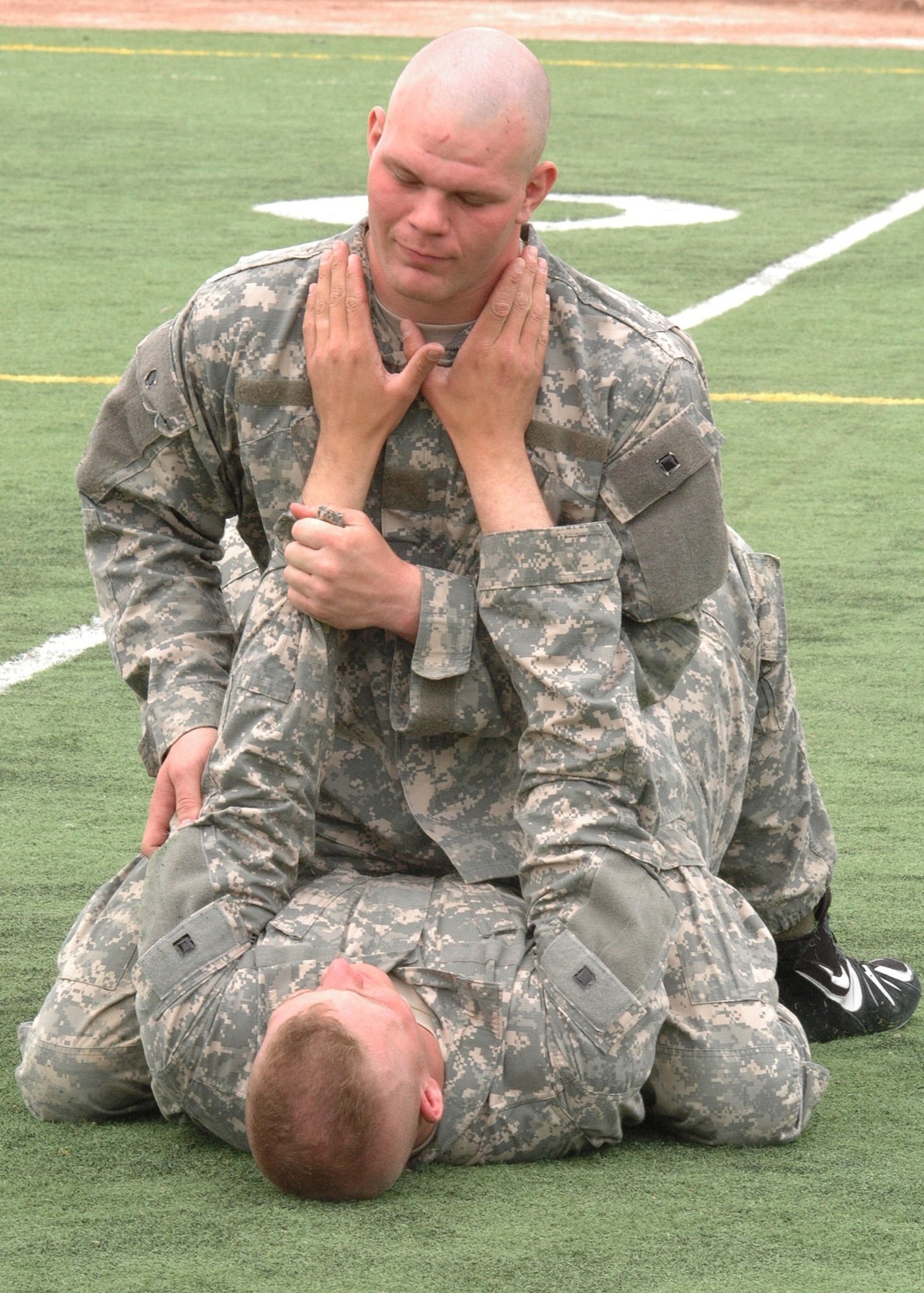 Two Army Soldier from Fort Bliss, Texas,  explain a hand-to-hand combat manuever to over 80 Airmen fro the 49th Civil Engineer Squadron March 21. (U.S. Air Force photo by Airman 1st Class John Strong)