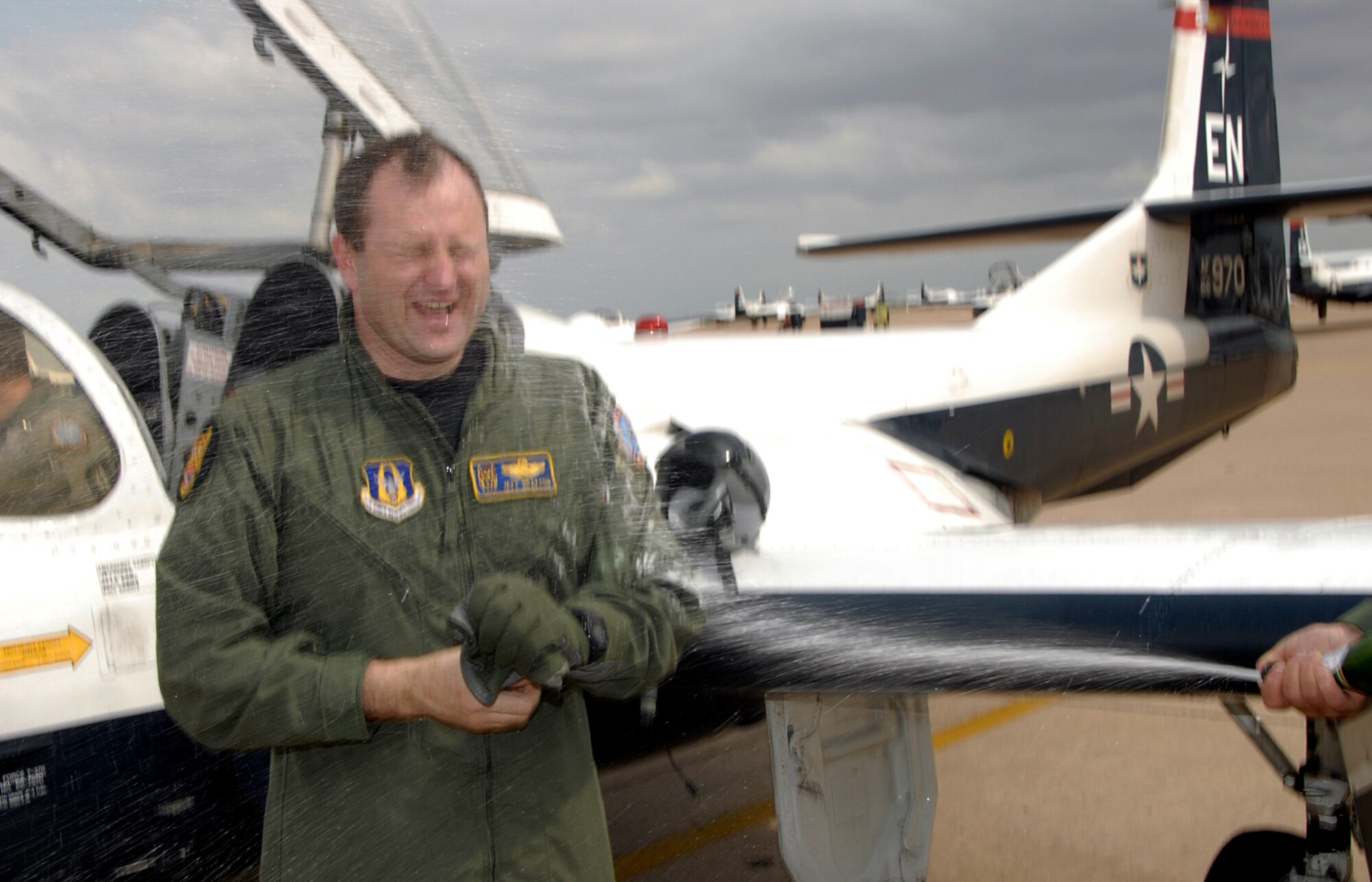 Maj. Jeff Grayson disembarks a T-37 Tweet to a shower of champagne Feb. 23.  Major Grayson, a reservist with the 97th Flying Training Squadron, completed his 3,000th hour of flying that afternoon. (U.S. Air Force photo/Sandy Wassenmiller)