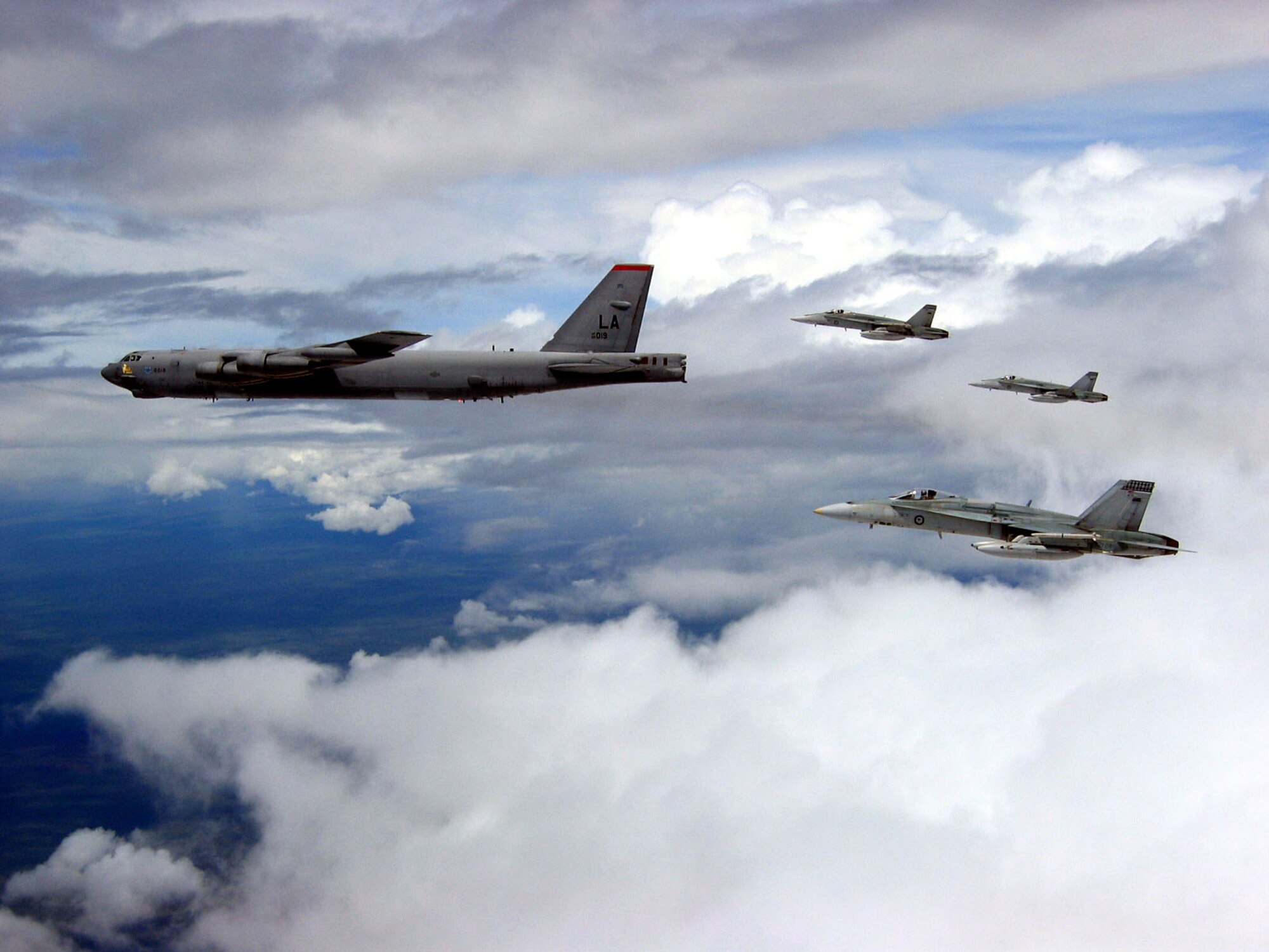 A B-52 Stratofortress from Andersen Air Force Base, Guam, is escorted by Hornets from the Royal Australian Air Force March 21 en route to the Delamere Bombing Range as part of the Green Lightning exercise that ended last week in Australia. The Delamere Bombing Range facility in the Northern Territory is a world class military exercise site that allows many skills to be honed and tested. (Royal Australian Air Force photo/Flight Lt. Steven Bradley) 