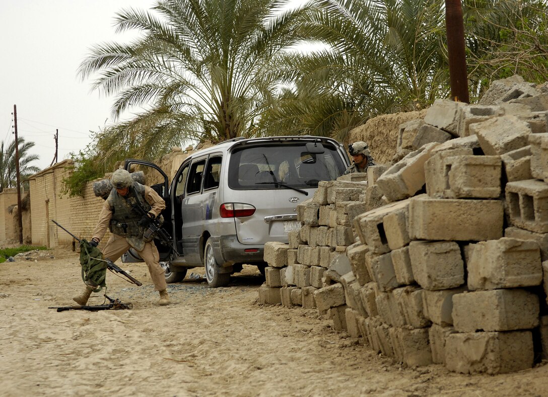 U.S. Army Staff Sgt. Jeriah McAvin and Sgt. Richard Grimsley discover a weapons cache in an abandoned van during an operation in Qubbah, Iraq, March 24, 2007. The soldiers are assigned to Charlie Troop, 82nd Airborne Division, out of Fort Bragg, N.C.