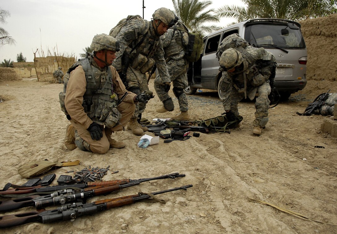 U.S. Army soldiers examine weapons discovered in an abandoned van in Qubbah, Iraq, March 24, 2007. The soldiers are assigned to Charlie Troop, 82nd Airborne Division, out of Fort Bragg, N.C.