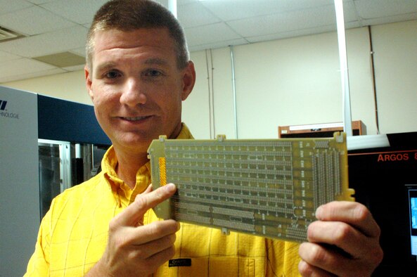 Marty Sheppard holds a finished back plane used in a AN/ALR 56M system. U.S. Air Force photo by Sue Sapp 
