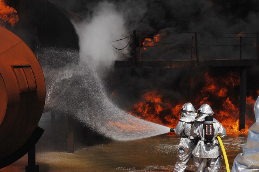 Staff Sgt. Michael Rolirad and Airman 1st Class Daniel Porter, 7th Civil Engineer Squadron firefighters, extinguish a simiulated aircraft fire here March 27. The firefighters extinguish simulated fires monthly to ensure their skills are perfect and they are prepared for actual emergencies. (U.S. Air Force photo by Airman Jennifer Romig)