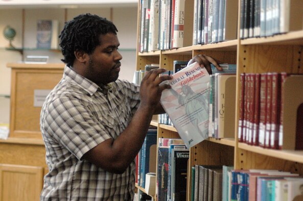 Carles Blackmon, library aide, shelves a book at the Base Library. U.S. Air Force photo by Sue Sapp 

