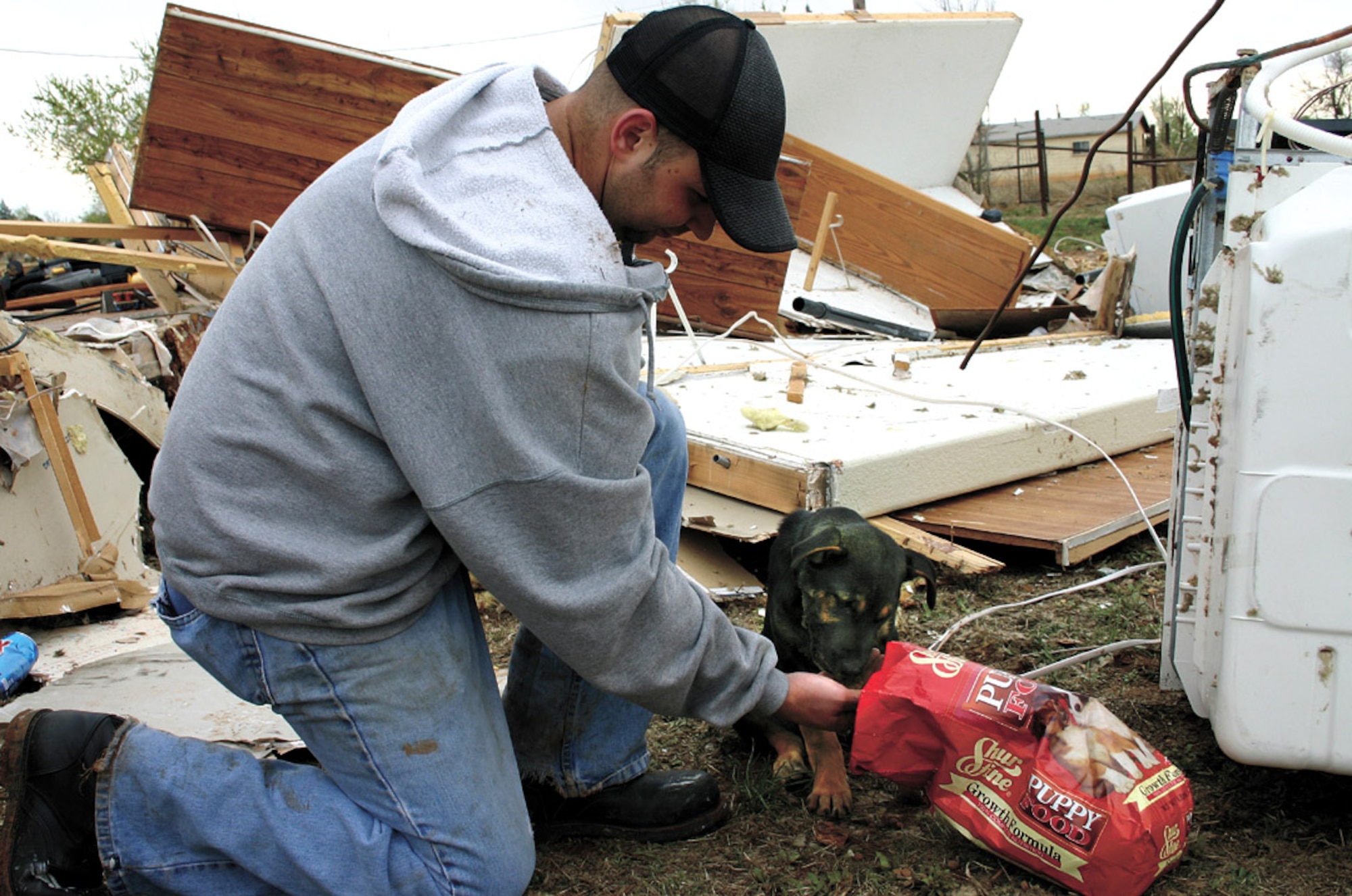 Staff Sgt. Obed Brown feeds a dog made stray by a tornado that struck Clovis, N.M., March 23. More than 500 volunteers from nearby Cannon Air Force Base stepped up to help their host city in time of need. Sergeant Obed is assigned to the 27th Component Maintenance Squadron. (U.S. Air Force photo/2nd Lt. George Tobias) 