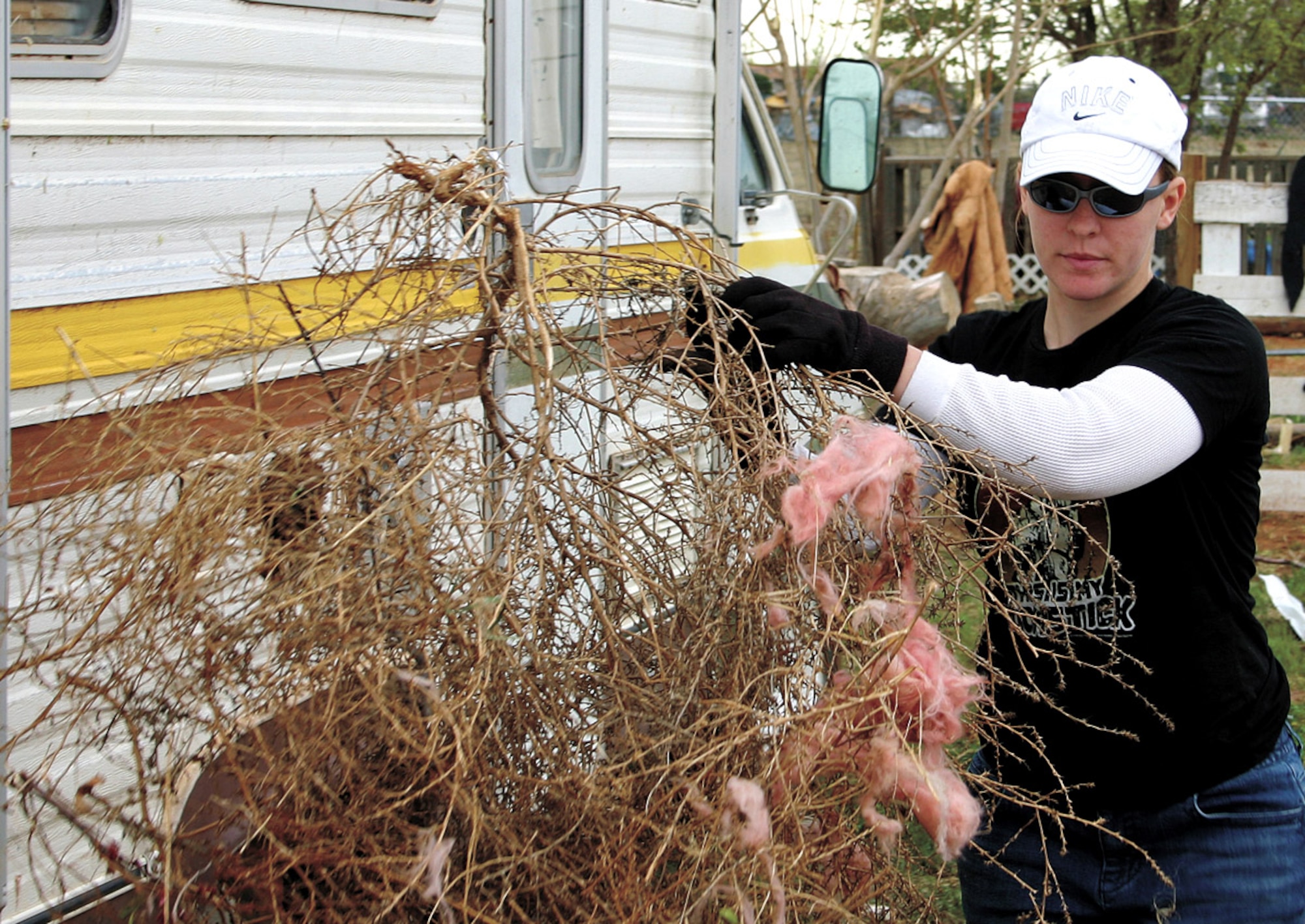 Senior Airman Christine O'Donnell clears out tumbleweeds during the clean up efforts March 25 in Clovis, N.M. More than 500 volunteers from Cannon Air Force Base began restoring the host city located six miles east of the base, after tornadoes ripped through the town March 23. Airman O'Donnell is assigned to the 27th Aircraft Maintenance Squadron. (U.S. Air Force photo/2nd Lt. George Tobias)