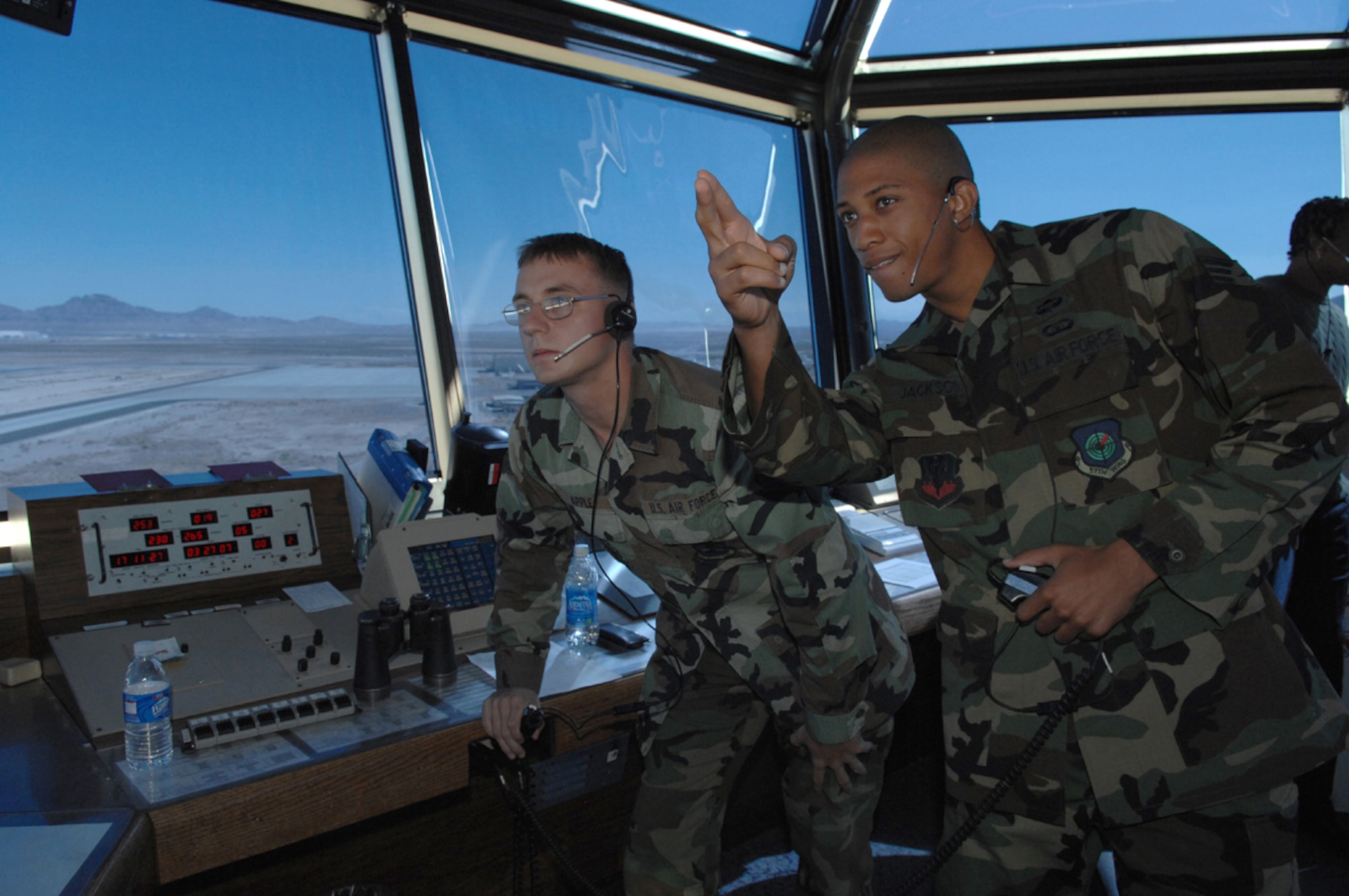 Senior Airman Lynn Jackson (right) is working the 'local controller' position, which is responsible for runway and air space operations at the Nellis Control Tower.  Airman 1st Class Scott Apple is in training for the position. (U.S. Air Force photo/Airman 1st Class Kasabyan McGarvey)