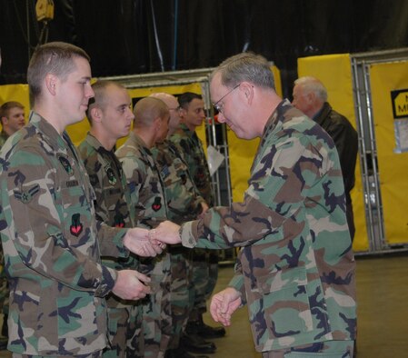 Maj. Gen. Kevin Sullivan, Ogden Air Logistics Center commander, greets and coins Airman 1st Class Michael OHarrow and all other members of the 388th Equipment Maintennace Squadron corrosion shop for the efforts made in restoring the P-47. (U.S. Air Force photo by Airman 1st Class Stefanie Torres)