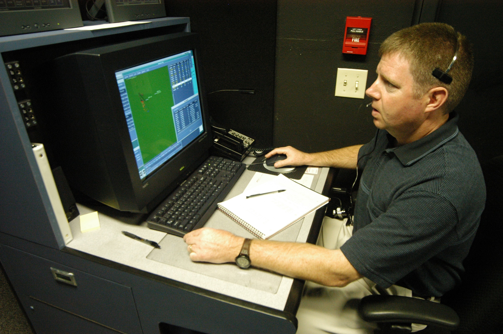 Robert Harvey manipulates a  program on the control tower simulator. He can add extra aircraft or change weather conditions. U. S. Air Force photo by Sue Sapp 