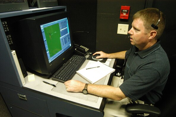 Robert Harvey manipulates a  program on the control tower simulator. He can add extra aircraft or change weather conditions. U. S. Air Force photo by Sue Sapp 