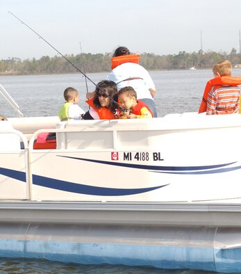 Mikoko Patt, left, wife of Robert Patt, 333rd Training Squadron, watches as their 4-year-old son, Samuel, fishes from a pontoon boat in Biloxi’s Back Bay.  The airman and family readiness center sponsored a fishing trip for families of deployed Keesler personnel Saturday.  (U.S. Air Force Photo by Tech. Sgt. Chuck Marsh)