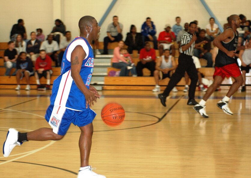 Dewayne Bennett (13), 60th Aerial Port Squadron, dribbles the ball down the court during the Intramural Basketball championship game at the Travis Fitness Center March 26. The 573rd GSS held on to defeat the 60th APS, 50 to 48. (U.S. Air Force photo by Tech. Sgt. Donald Osborn)
