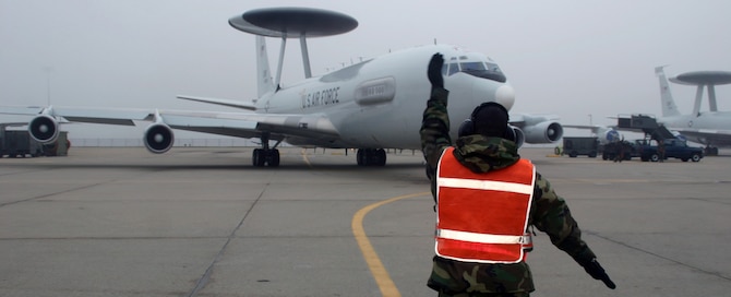 An Airman from the 552nd Aircraft Maintenance Squadron marshals the first of several aircraft out of its parking spot and on its way to support Operations ENDURING FREEDOM and IRAQI FREEDOM Mar. 28. (Air Force photo by Staff Sgt. Stacy Fowler)