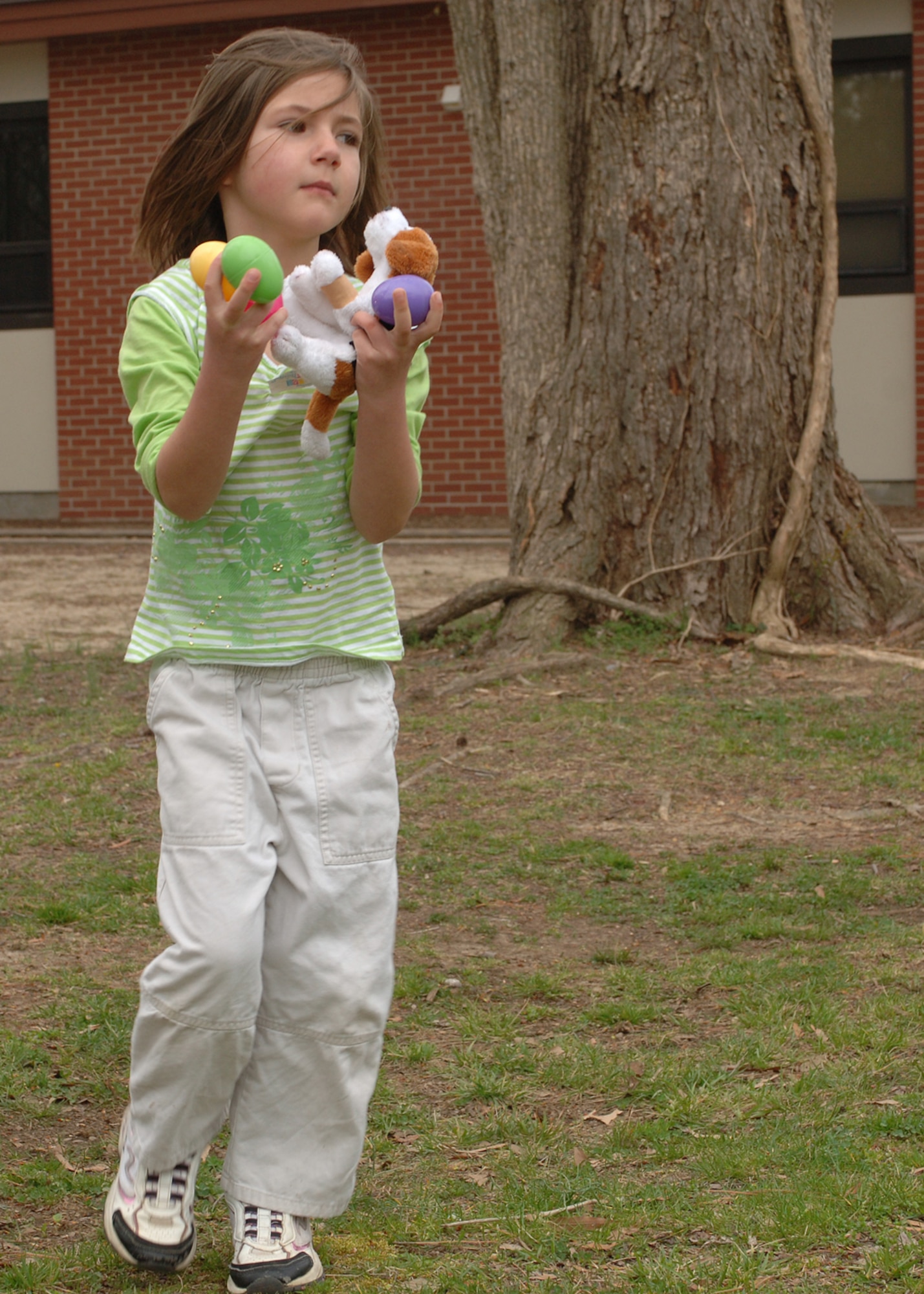 Shelby Briody juggles to pick up the next egg during the Easter egg hunt at Bethel Chapel March 24. The egg hunt is sponsored by Air Force Sergeants Association Chapter 358 to promote community activities for the young children. (U.S. Air Force photo/Airman 1st Class Nguyen)