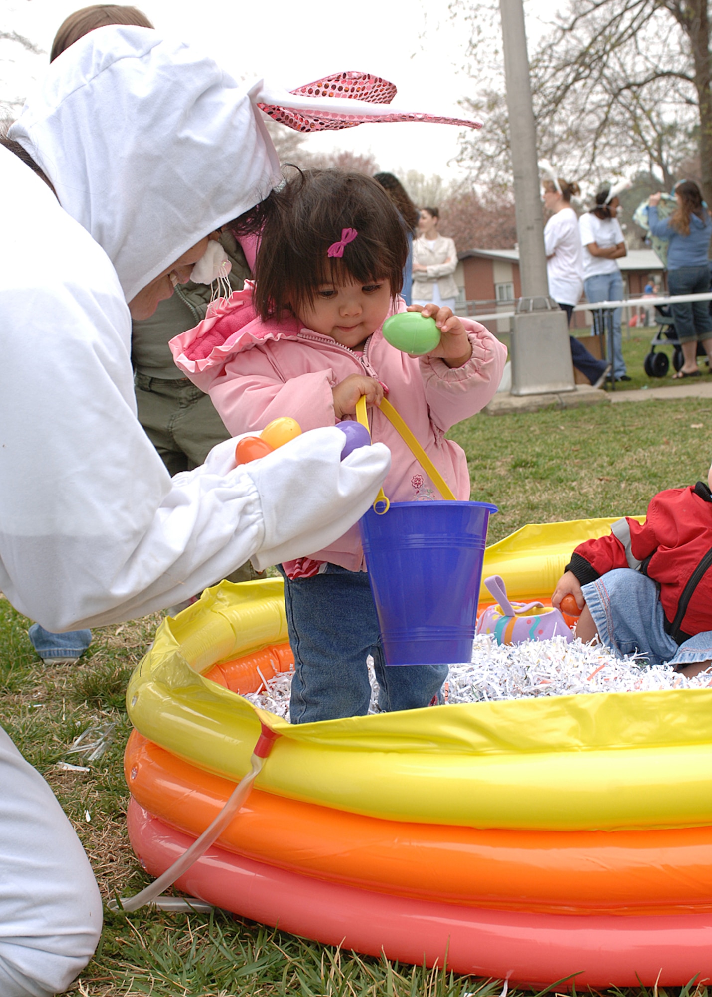 The Easter bunny, also known as Tech. Sgt.  Rachel Vis, 497th Inspector General staff, shares some eggs with Vanessa Nikitin at Bethel Chapel March 24.  The Easter egg hunt event is sponsor by Air Force Sergeants Association Chapter 358 to promote community activities for the young children. (U.S. Air Force photo/Airman 1st Class Alex Nguyen)