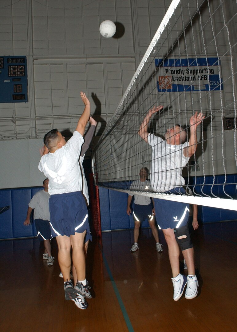 Tech. Sgt. Jonathan Viladiu, left, from the 93rd Intelligence Squadron, and Tech. Sgt. Eric Soluri, from the 345rd Training Squadron, leap for the ball during a single-man elimination round of volleyball March 23 at the Warhawk Fitness Center on Lackland Air Force Base, Texas. The friendly competition was part of a new Robert D. Gaylor NCO Academy Team Challenge involving 15 flights of 174 NCOs in the current six-week class. (USAF photo by Alan Boedeker)                               