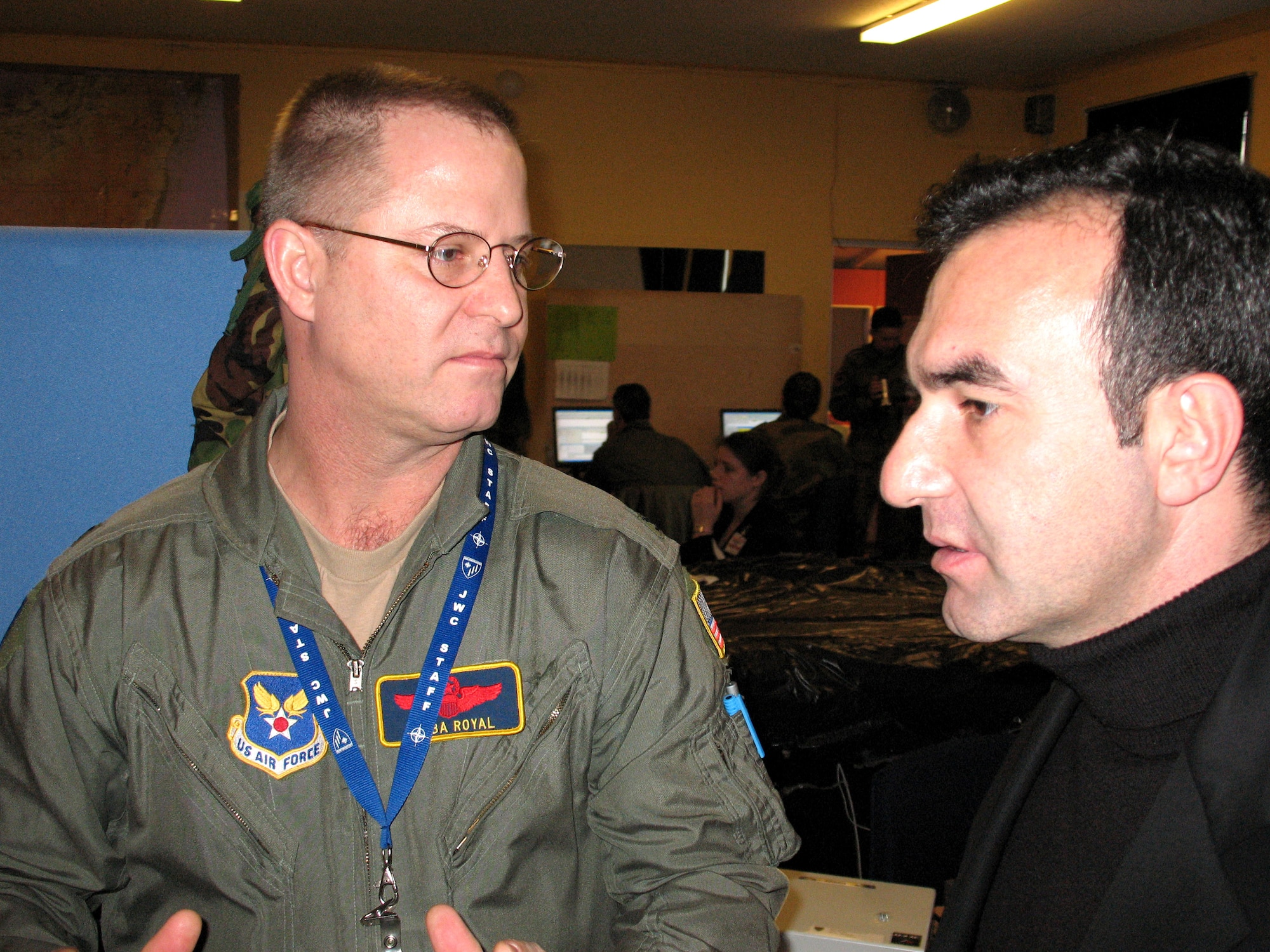 Col. David Royals talks to Yavuz Okur during Exercise Enabler 2007 March 28 at Ramstein Air Base, Germany. The exercise tested new tools for upcoming JWC exercises. Colonel Royals is an Air Doctrine staff officer at the Joint Warfare Center in Stavanger, Norway. Mr. Okur is a computer systems analyst. (U.S. Air Force photo/Staff Sgt. Leigh Bellinger)