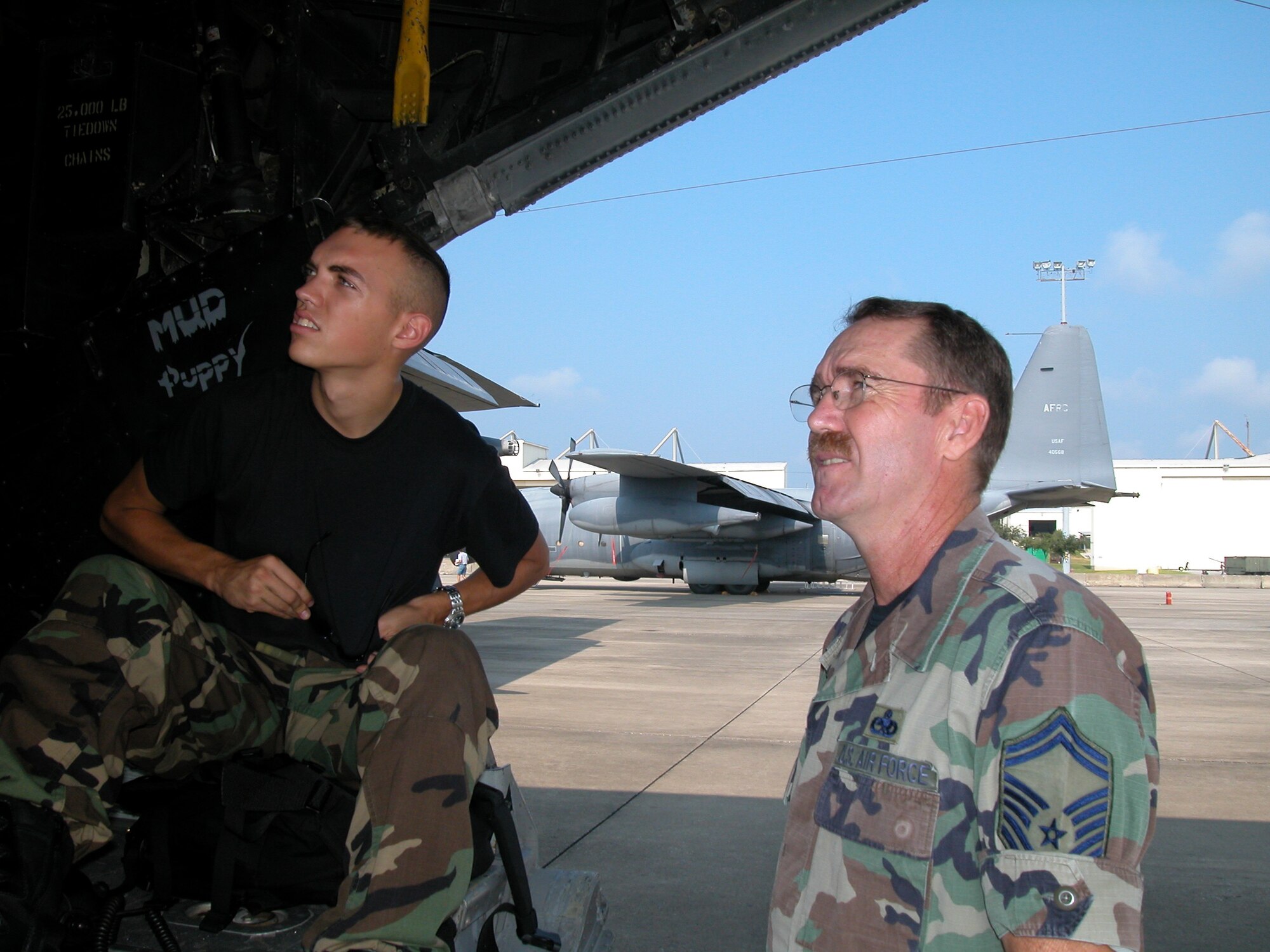 Chief Master Sgt. Phillip Bahm (then a senior master sergeant) chats with an Airman on the ramp of an MC-130E.  The chief was decorated for recovering an MC-130E aircraft during a daring mission in Afghanistan. (U.S. Air Force file photo)