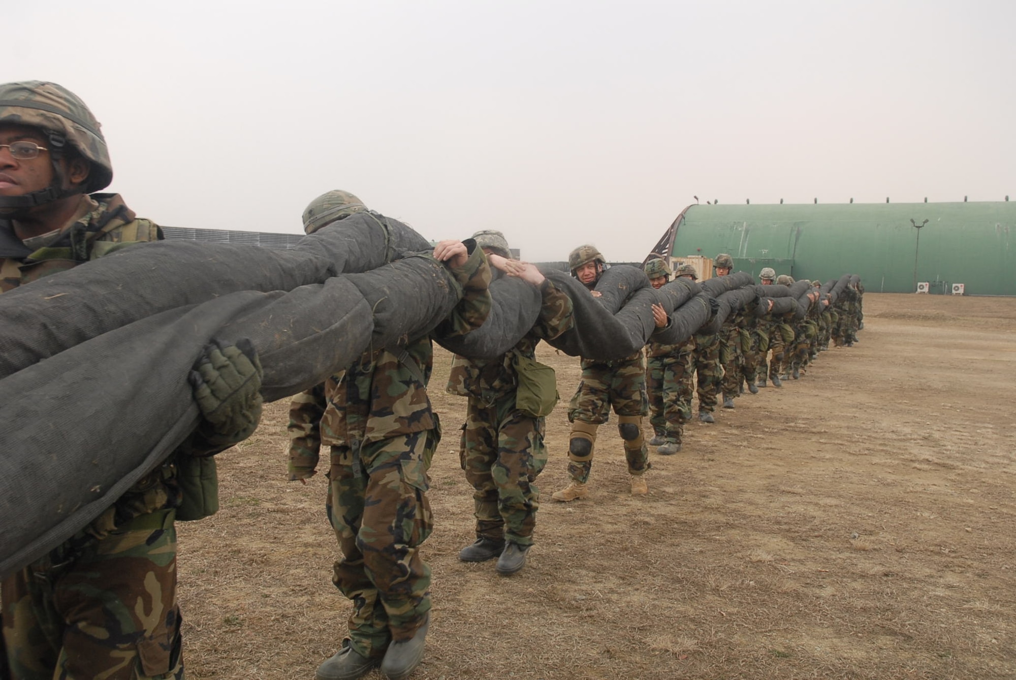 OSAN AIR BASE, Republic of Korea --  Soldiers of Headquarters and Headquarters Battery, 35th Air Defense Artillery Brigade roll up and load the huge camouflage net affectionately referred to as “Big Bertha” during a recent brigade field training exercise held in conjunction with the Reception, Staging, Onward-movement and Integration exercise. During the FTX, all 14 units within the brigade across peninsula participated, refining their Patriot skills as well as concentrating on force protection and weapons immersion. (U.S. Army photo)
