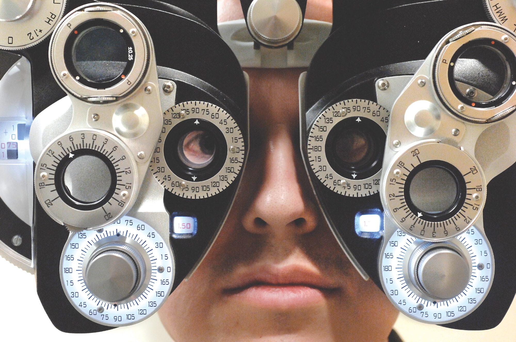 MCCHORD AIR FORCE BASE, Wash. -- A patient peers through a phoropter March 15 during a visit to the base optometry clinic.  A phoropter is an instrument commonly used by optometrists during an eye examination to measure an individual's refractive error and determine his eyeglass prescription. (U.S. Air Force photo/Abner Guzman)