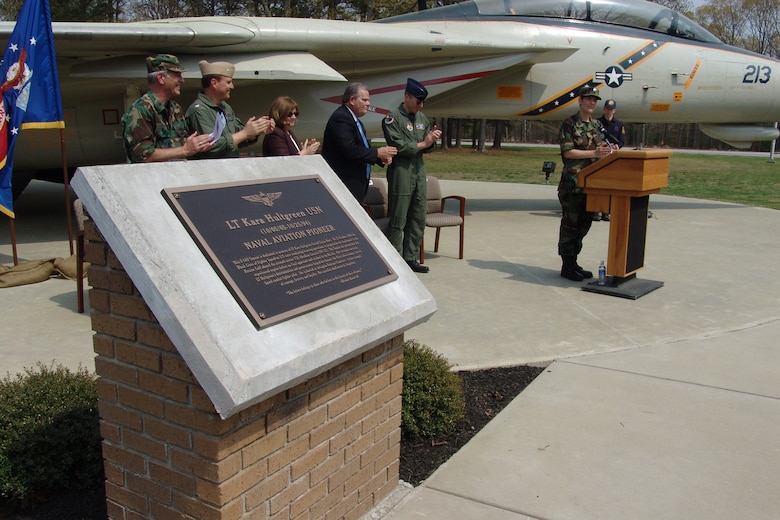 The F-14D Tomcat static display aircraft at Arnold Air Force Base, Tenn., was dedicated March 30 in honor of the late Lt. Kara Hultgreen, the Navy’s first female carrier-based combat fighter pilot. She was assigned to the Black Lions of Fighter Squadron 213 aboard the aircraft carrier USS Abraham Lincoln.  The F-14 dedicated in her honor was assigned to the same squadron. (Left to right) Chaplain (Lt. Col.) Martin Nutter, AEDC Vice Commander Navy Capt. Bob Roof, retired Navy Capt. Rosemary Mariner, James Spears, AEDC Commander Arthur Huber, Lt. Col. Kim Nelson and John Lominac applaud after the dedication plaque is unveiled. (Photo by Joel Fortner)